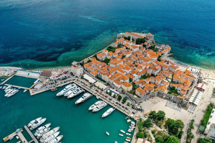 Widok z lotu ptaka na Stare Miasto w Budvie i marinę na wybrzeżu Adriatyku, Czarnogóra